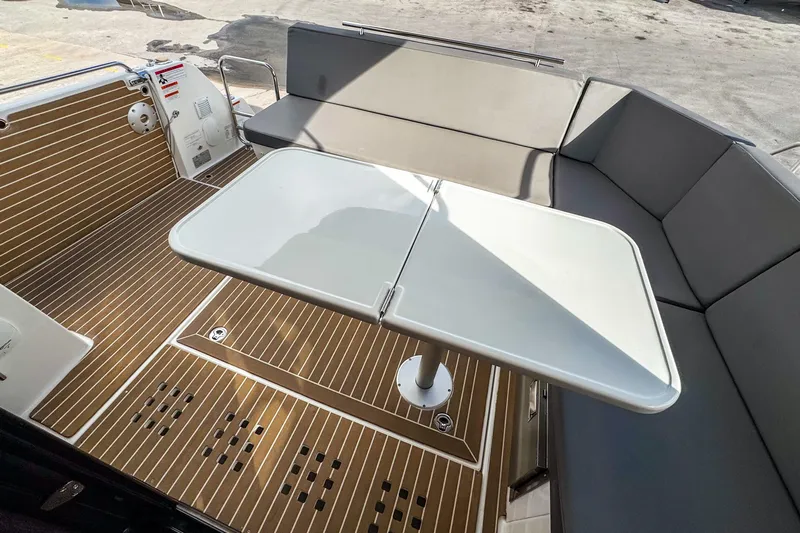  Yacht Photos Pics 2024 Beneteau Antares 11 boat interior with seating and foldable table.
