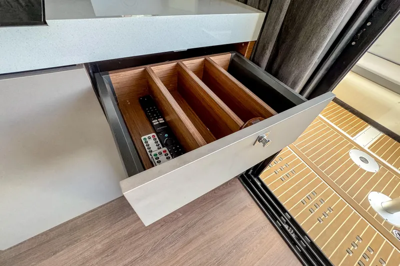  Yacht Photos Pics Open drawer with remote controls in 2024 Beneteau America Antares 11 boat interior.