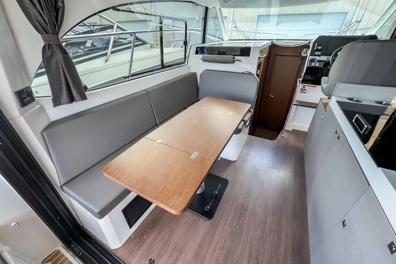  Yacht Photos Pics 2024 Beneteau Antares 11 interior with modern seating and wooden table.