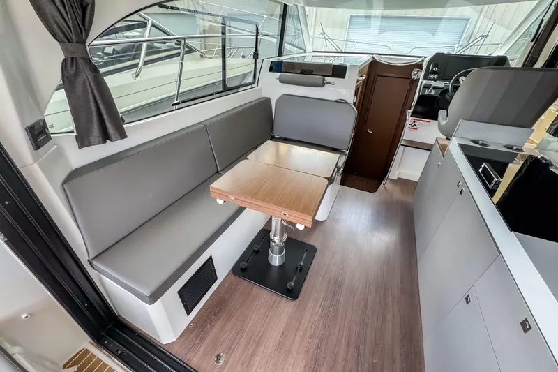  Yacht Photos Pics 2024 Beneteau Antares 11 interior with modern seating, table, and helm station.