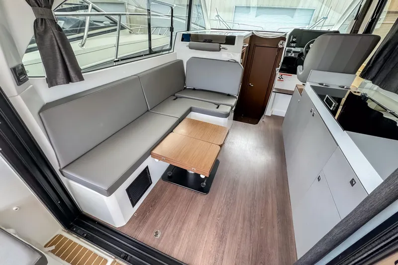  Yacht Photos Pics 2024 Beneteau America Antares 11 interior with modern seating and kitchenette.