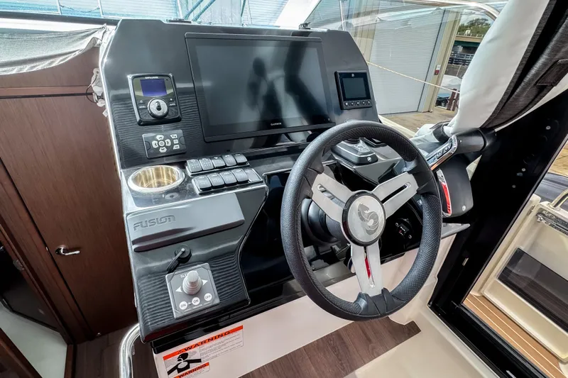  Yacht Photos Pics 2024 Beneteau Antares 11 helm with steering wheel, touchscreen, and control panel.