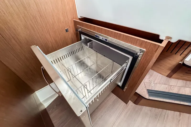  Yacht Photos Pics 2024 Beneteau Antares 11 interior with open stainless steel drawer refrigerator.