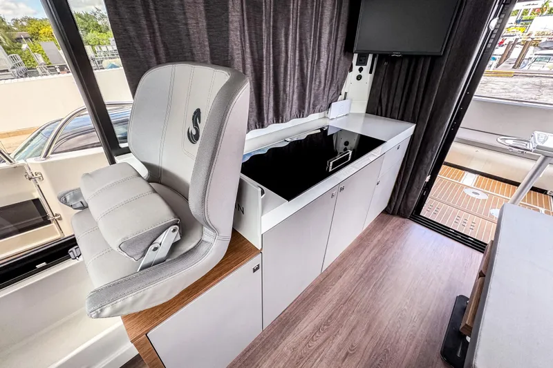  Yacht Photos Pics Interior of 2024 Beneteau America Antares 11, featuring helm seat and modern cabinetry.