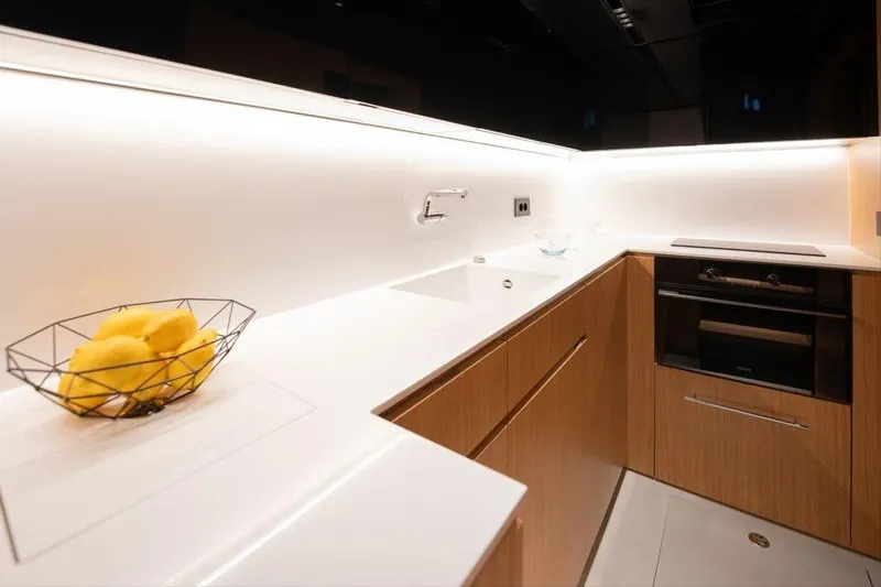  Yacht Photos Pics Modern kitchen interior on 2025 De Antonio Yachts D60, featuring sleek design and wooden cabinetry.