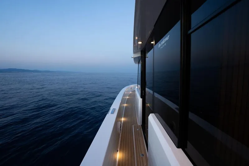  Yacht Photos Pics 2025 De Antonio Yachts D60 cruising at dusk, showcasing sleek design and ocean view.