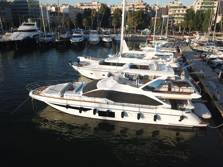 Goldinia Yacht Photos Pics Luxurious 2021 Azimut 72 yacht docked in a marina, surrounded by other boats.
