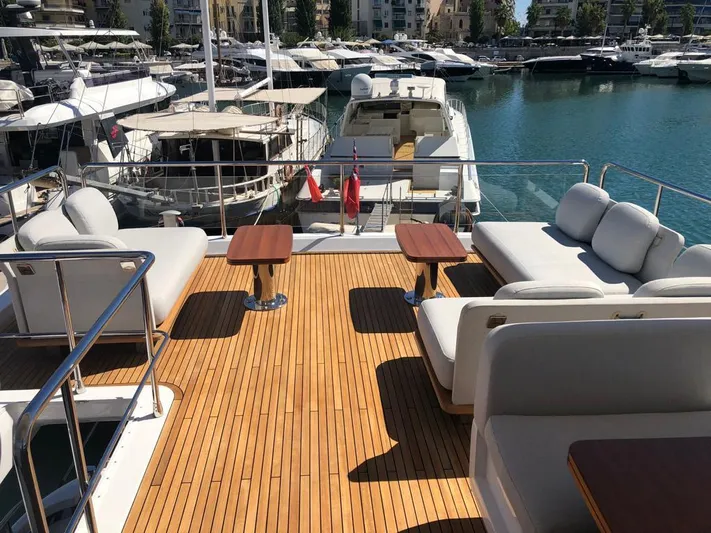 Goldinia Yacht Photos Pics Luxurious 2021 Azimut 72 yacht deck with elegant seating and tables, docked in a marina.