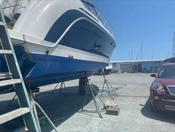  Yacht Photos Pics 2004 Formula 40 PC yacht on stands in a marina, with a car nearby.