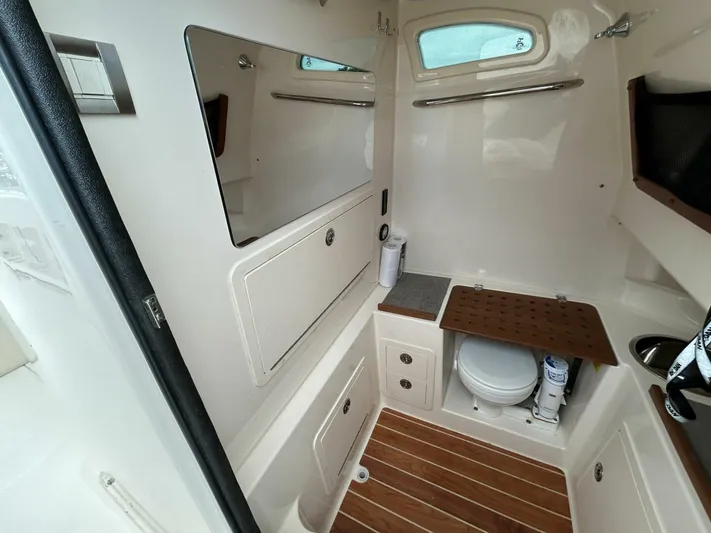  Yacht Photos Pics 2019 Grady-White 306 CANYON boat interior with toilet and wooden flooring.