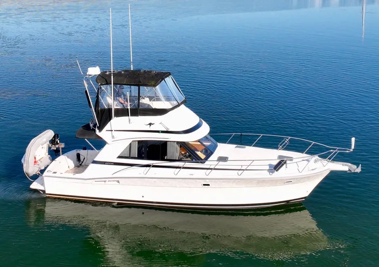 Walkabout Yacht Photos Pics 2001 Riviera Convertible boat cruising on calm water.