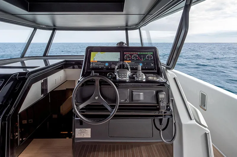 Bluegame Bg54#29 (new) Yacht Photos Pics 2025 Bluegame BG54 yacht helm with advanced navigation system, steering wheel, and ocean view.