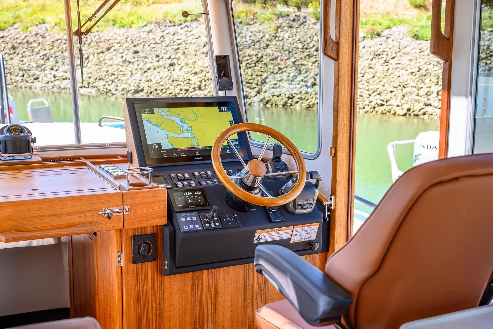 Interior of 2025 Targa 37 boat with navigation system and wooden steering wheel.