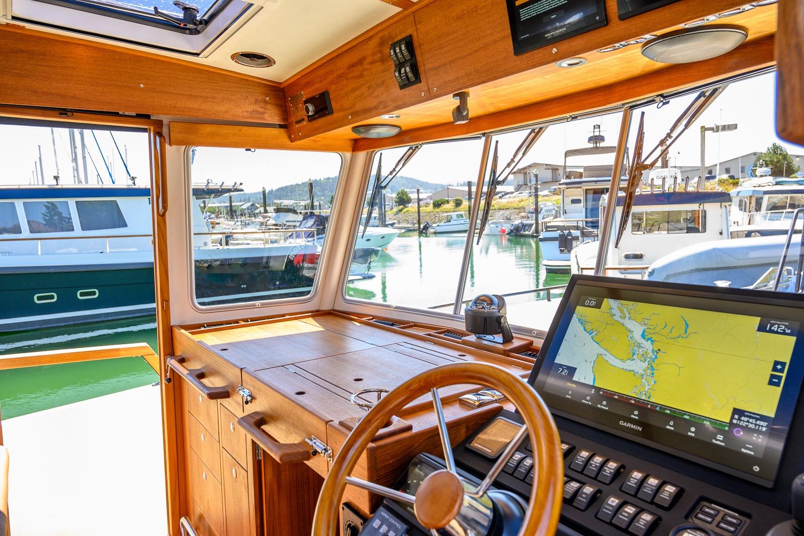 Interior view of 2025 Targa 37 boat cockpit with navigation system and marina background.