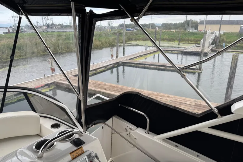  Yacht Photos Pics 2002 Silverton 352 Motor Yacht interior view at dock, featuring helm and seating area.