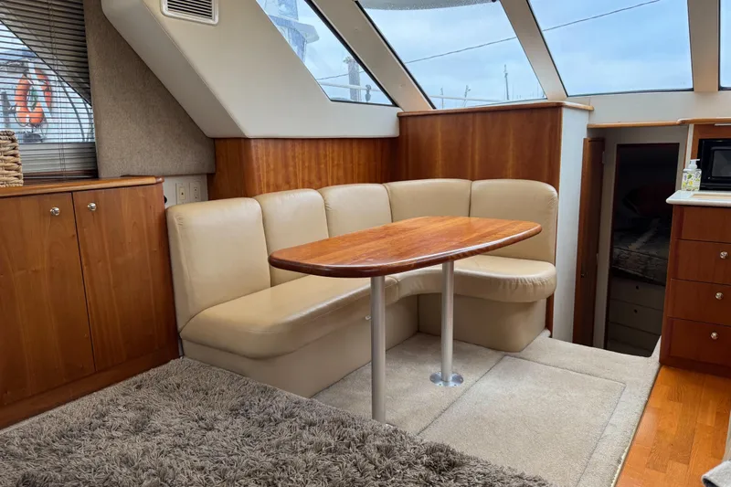  Yacht Photos Pics Interior of 2002 Silverton 352 Motor Yacht with beige seating and wooden table.