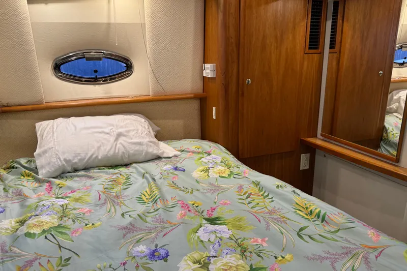  Yacht Photos Pics Cozy bedroom in 2002 Silverton 352 Motor Yacht with floral bedding and wooden cabinetry.