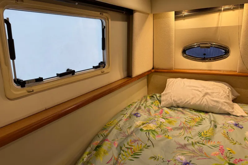  Yacht Photos Pics Cozy cabin interior of 2002 Silverton 352 Motor Yacht with floral bedding and porthole windows.