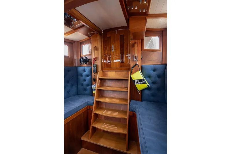  Yacht Photos Pics Interior of 2011 Spirit 50 DH yacht with wooden stairs and blue cushioned seating.