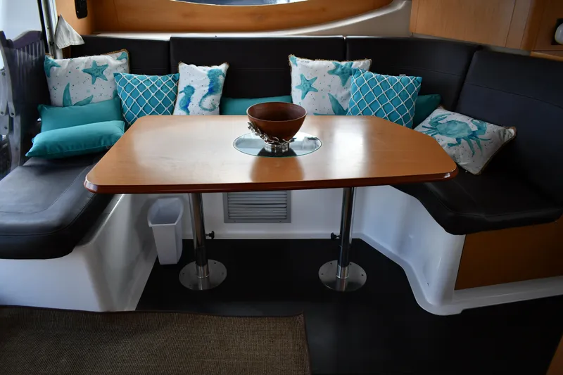 Beach Cat Yacht Photos Pics Cozy dining area in 2012 Fountaine Pajot 40 catamaran with decorative pillows and wooden table.