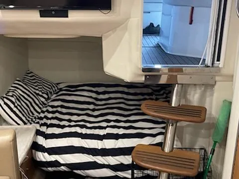  Yacht Photos Pics Interior cabin of 2014 Rinker 360 Express Cruiser with striped bedding and wooden steps.