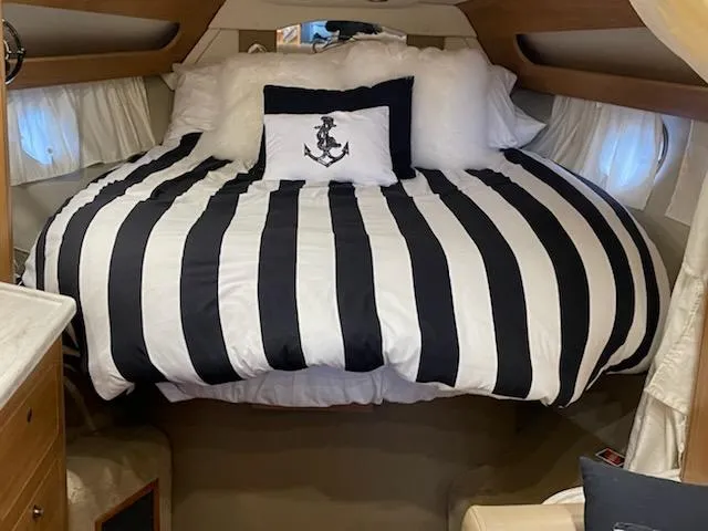  Yacht Photos Pics 2014 Rinker 360 Express Cruiser cabin with striped bedding and anchor pillow.
