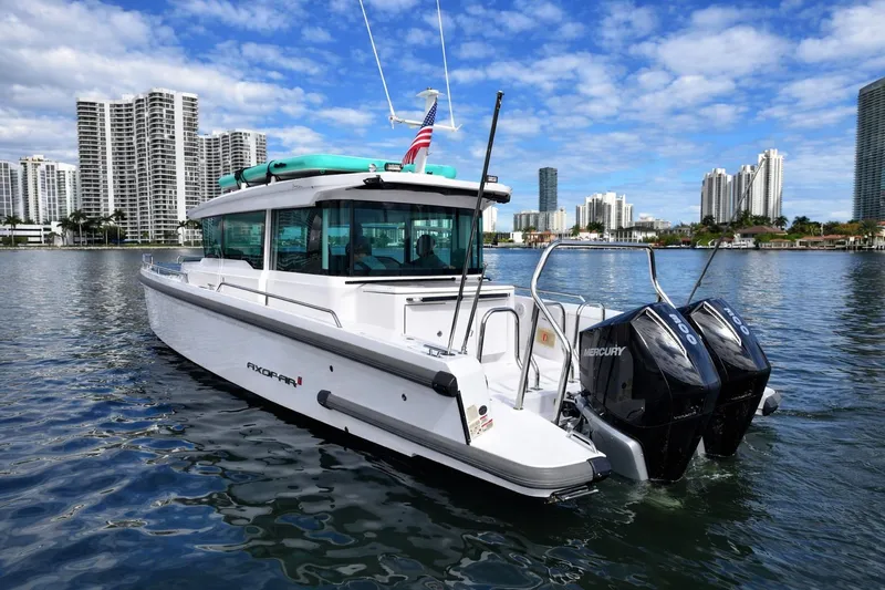  Yacht Photos Pics 2022 Axopar 37 XC Cross Cabin boat on water with city skyline background.