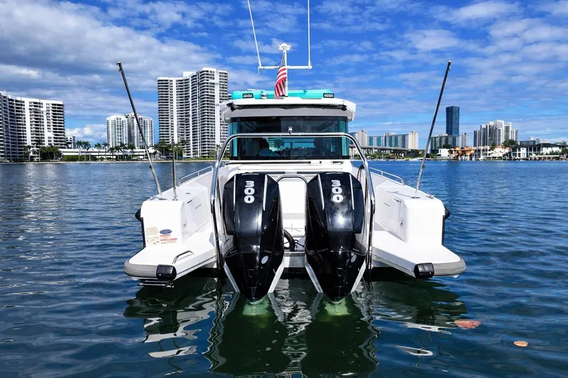  Yacht Photos Pics 2022 Axopar 37 XC Cross Cabin boat with dual engines on a sunny waterfront.