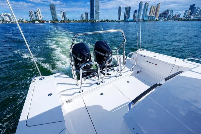 Yacht Photos Pics 2022 Axopar 37 XC Cross Cabin cruising near city skyline, featuring dual Mercury engines.