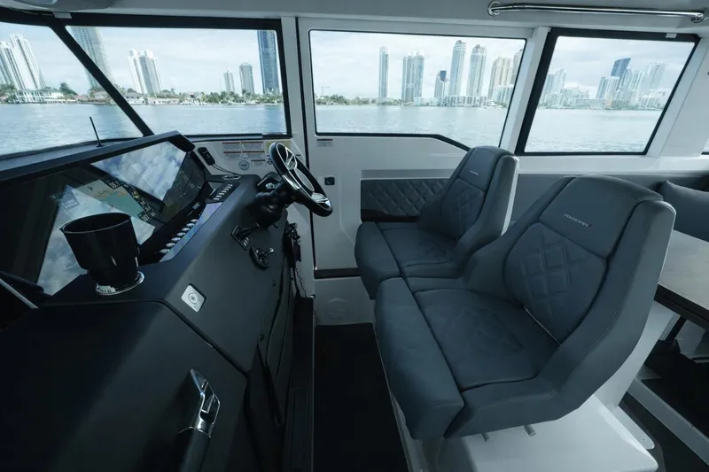  Yacht Photos Pics Interior of 2022 Axopar 37 XC Cross Cabin with modern seating and cityscape view.