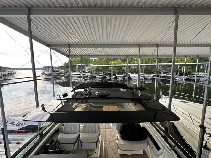  Yacht Photos Pics 2022 Sea Ray SLX 400 docked in a covered marina with other boats.