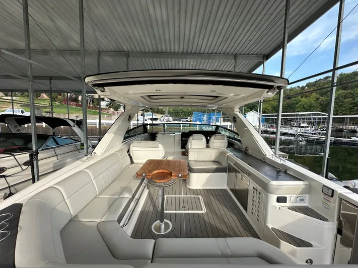  Yacht Photos Pics 2022 Sea Ray SLX 400 luxury boat interior with seating and table under a covered dock.