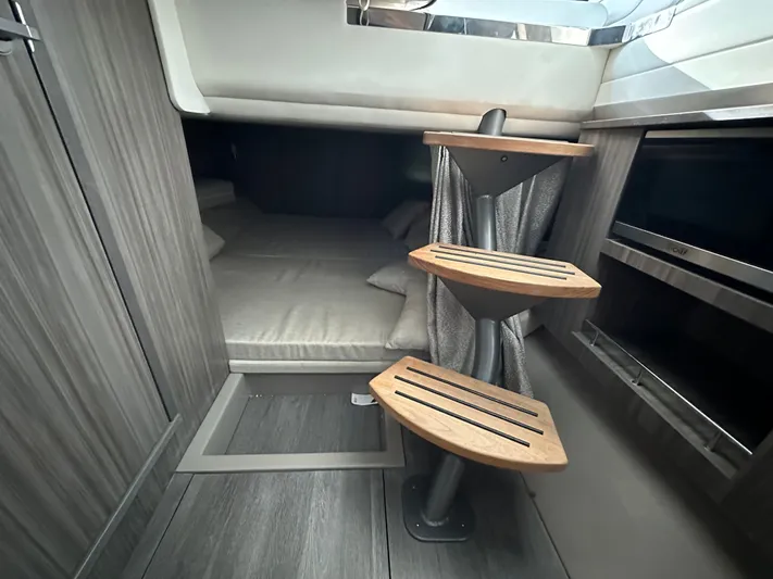  Yacht Photos Pics Interior cabin of 2022 Sea Ray SLX 400 with wooden steps and cozy bedding.