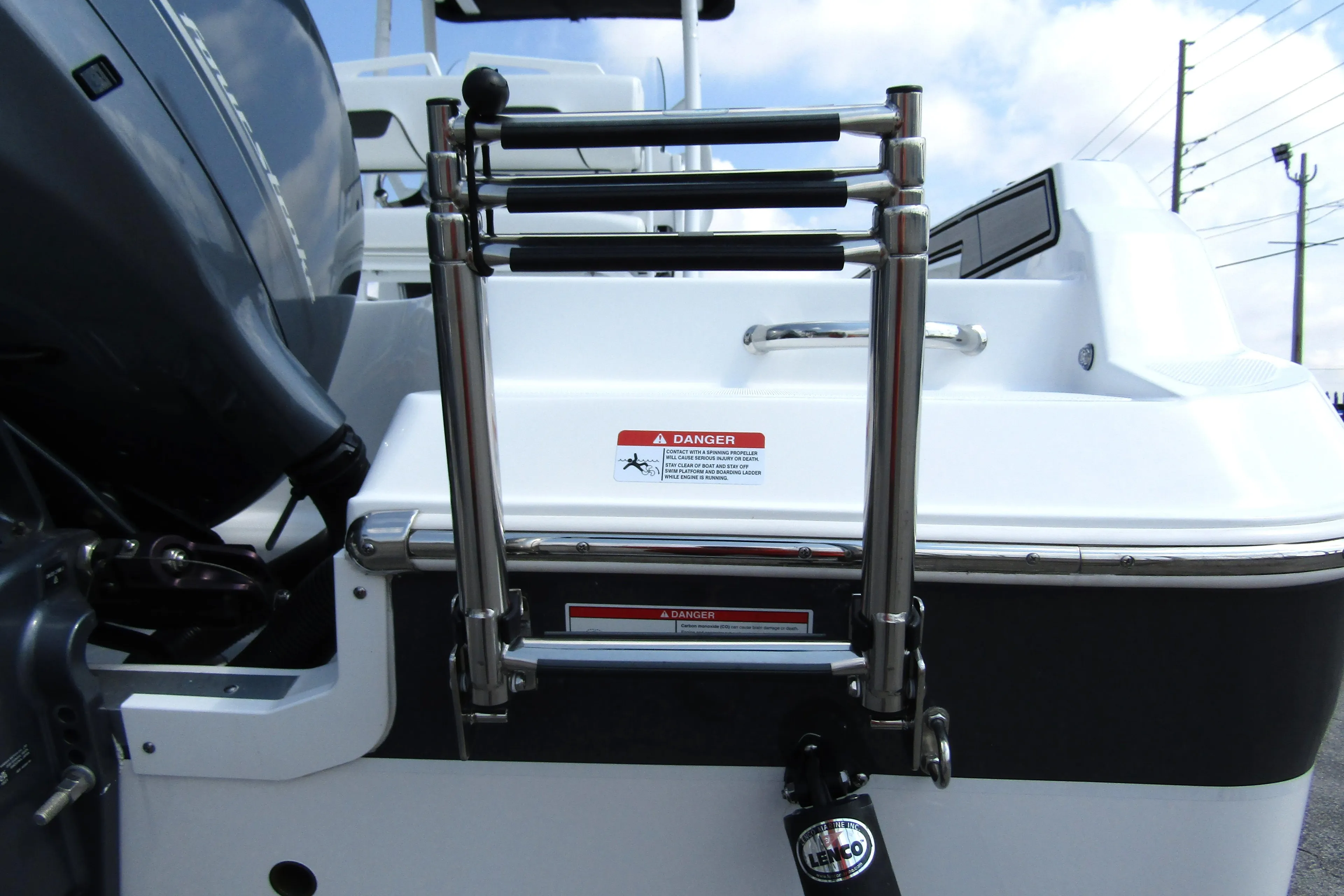 2024 Wellcraft 202 Fisherman boat ladder and engine detail under a blue sky.