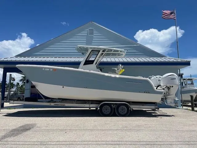  Yacht Photos Pics 2024 World Cat 260 CC-X boat on trailer, parked near a building with an American flag.