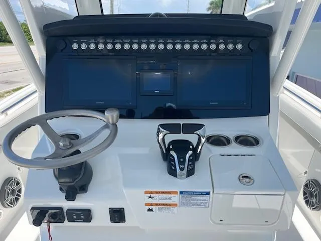  Yacht Photos Pics 2024 World Cat 260 CC-X boat dashboard with steering wheel and control panel.