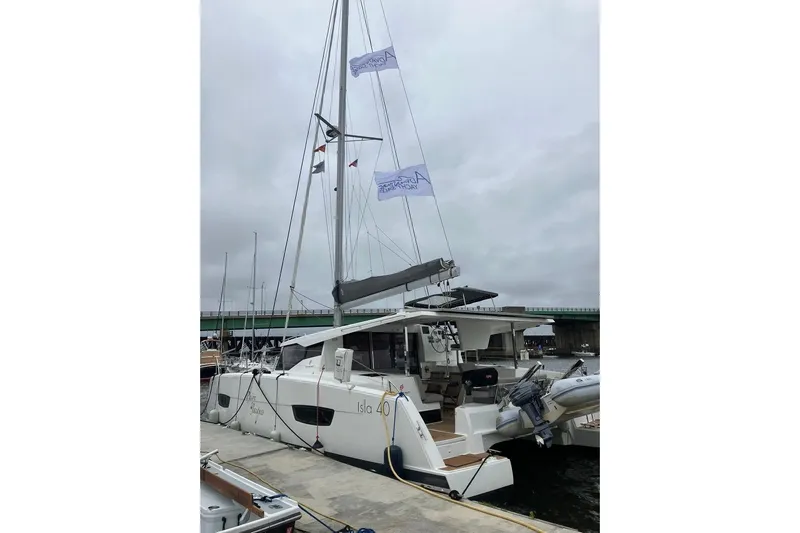 Paire De Jacques Yacht Photos Pics 2021 Fountaine Pajot Isla 40 catamaran docked at a marina under cloudy skies.