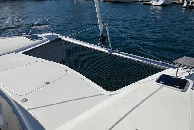 Paire De Jacques Yacht Photos Pics 2021 Fountaine Pajot Isla 40 catamaran deck with netting, docked in marina.