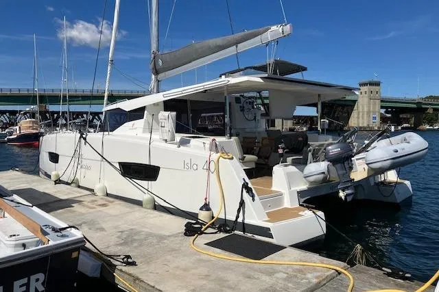 Paire De Jacques Yacht Photos Pics 2021 Fountaine Pajot Isla 40 catamaran docked at marina under clear blue sky.