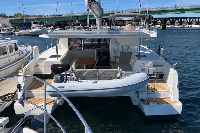 Paire De Jacques Yacht Photos Pics 2021 Fountaine Pajot Isla 40 catamaran docked at marina, featuring spacious deck and tender.