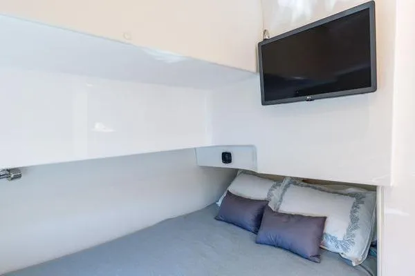  Yacht Photos Pics 2023 Intrepid 438 Evolution cabin with bed, pillows, and wall-mounted TV.