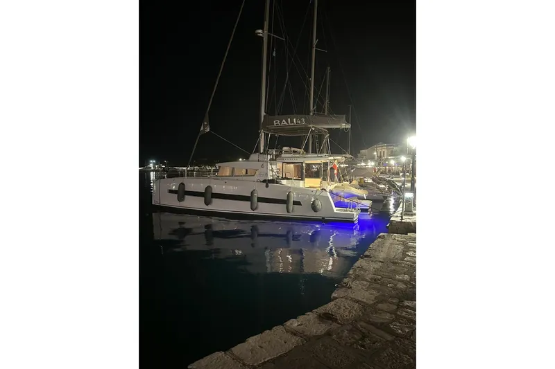  Yacht Photos Pics 2017 Bali 4.3 catamaran docked at night with blue underwater lights.