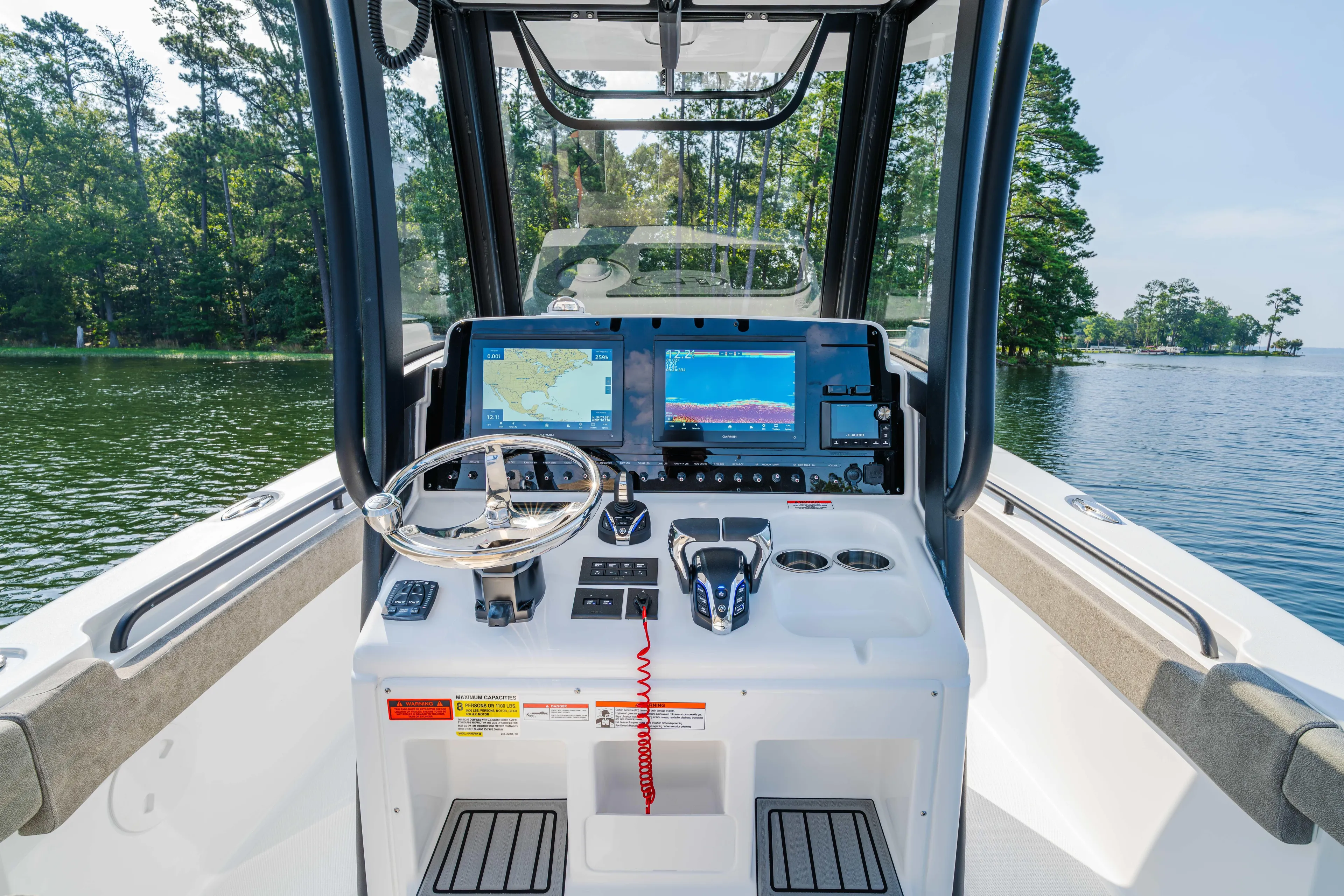  Yacht Photos Pics 2026 Sea Hunt Gamefish 25 boat dashboard with navigation screens on a serene lake.