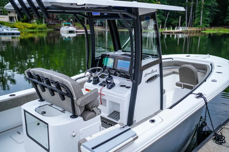 Yacht Photos Pics 2026 Sea Hunt Gamefish 25 boat with modern console and seating, docked on a serene lake.