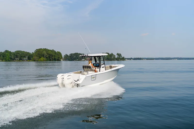 Yacht Photos Pics 2026 Sea Hunt Gamefish 25 cruising on a serene lake with lush green shoreline.