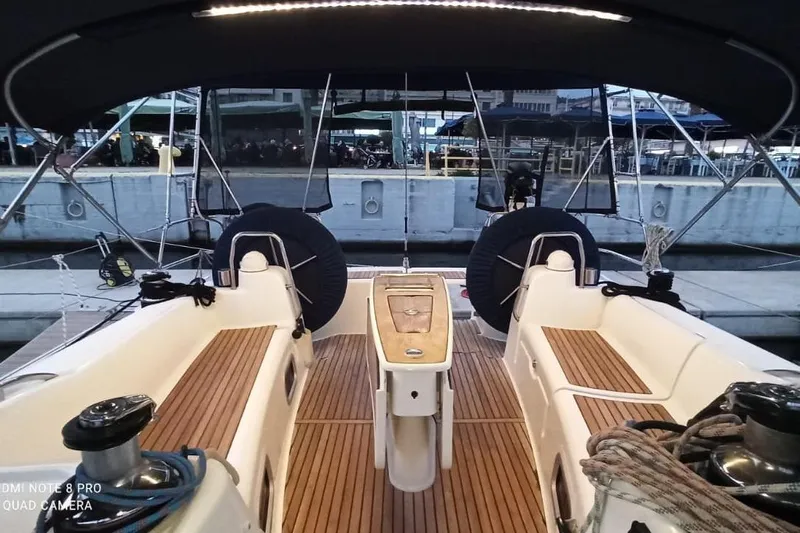 Pain Killer Yacht Photos Pics Cockpit view of 2009 Beneteau Oceanis 46 sailboat with wooden deck and seating.