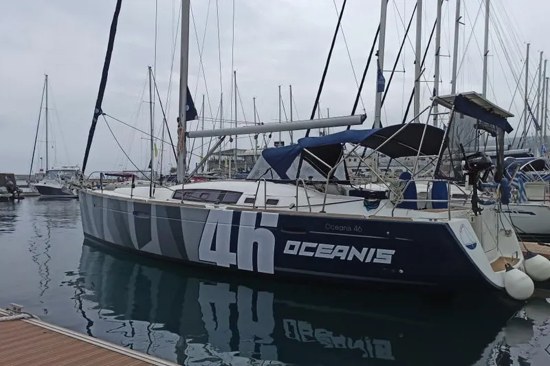 Pain Killer Yacht Photos Pics 2009 Beneteau Oceanis 46 sailboat docked in a marina, overcast sky.