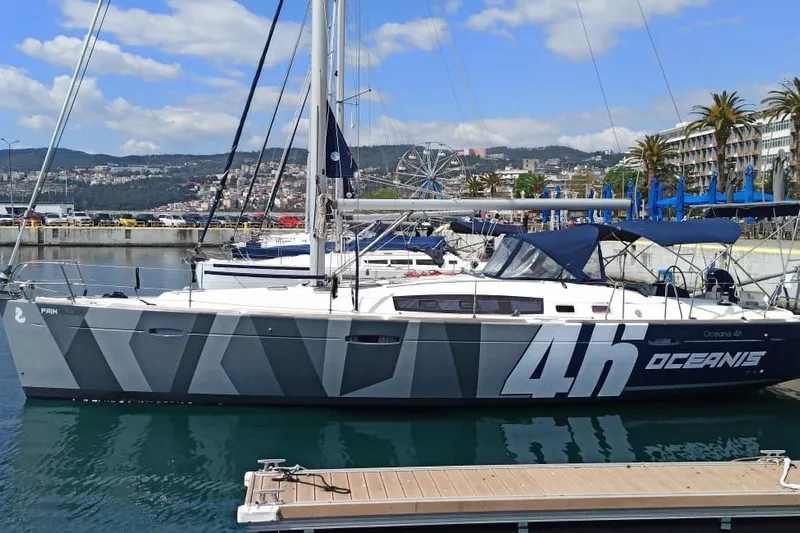 Pain Killer Yacht Photos Pics 2009 Beneteau Oceanis 46 sailboat docked in a marina with cityscape background.