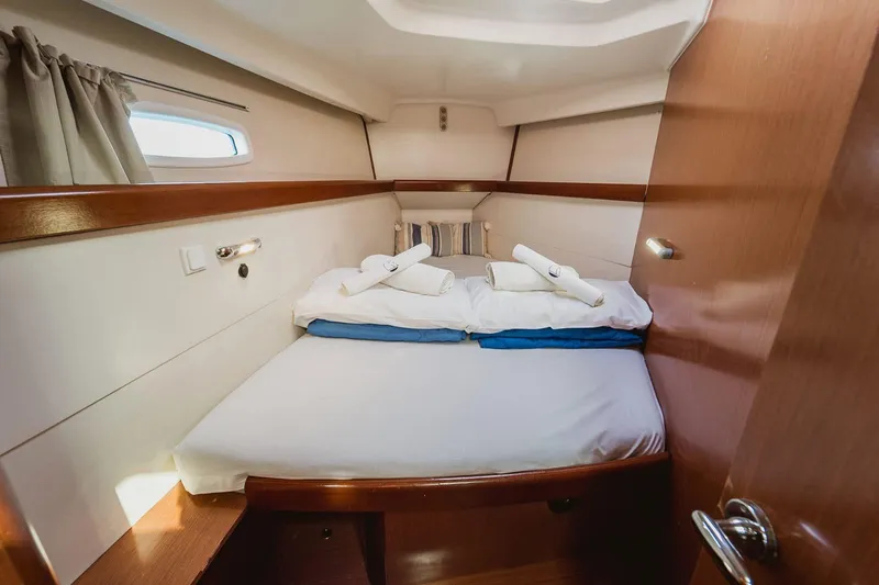 Pain Killer Yacht Photos Pics Cozy cabin interior of 2009 Beneteau Oceanis 46 yacht with neatly arranged bedding.
