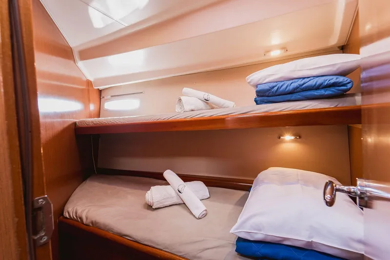 Pain Killer Yacht Photos Pics Cozy cabin interior of 2009 Beneteau Oceanis 46 with bunk beds and soft lighting.